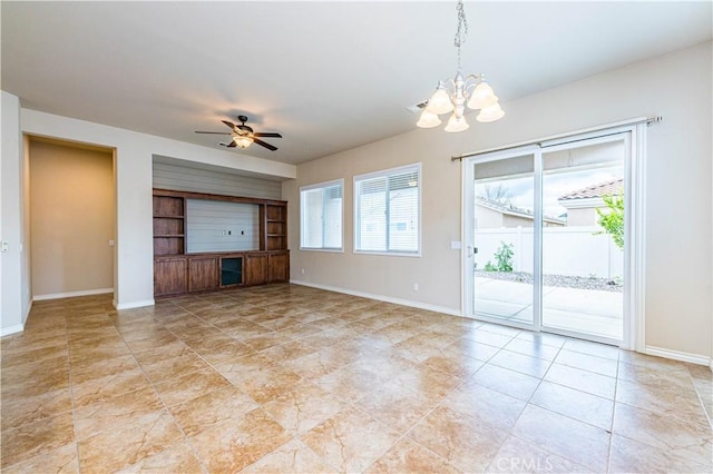 unfurnished living room featuring ceiling fan with notable chandelier