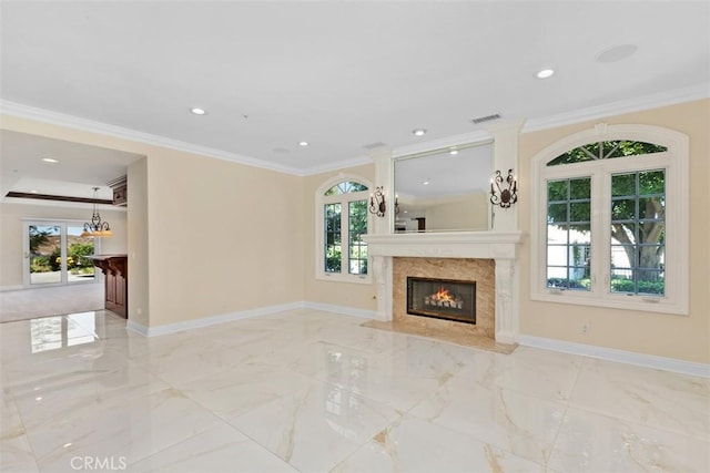 unfurnished living room with plenty of natural light, ornamental molding, and a high end fireplace