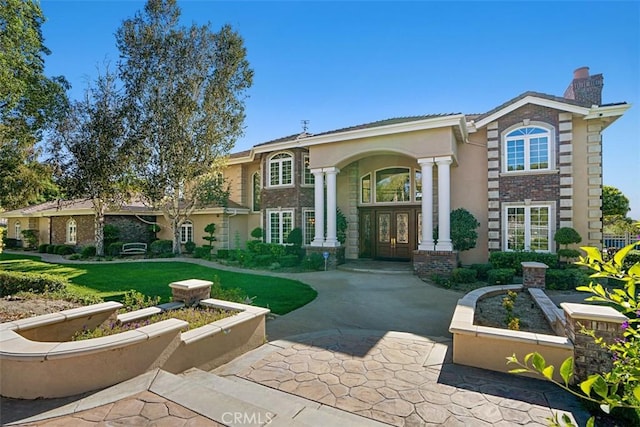 view of front of home with a front lawn and french doors