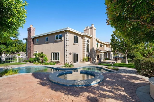 view of swimming pool featuring a patio area and an in ground hot tub