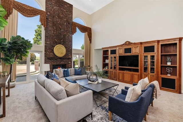 carpeted living room with a towering ceiling and a brick fireplace