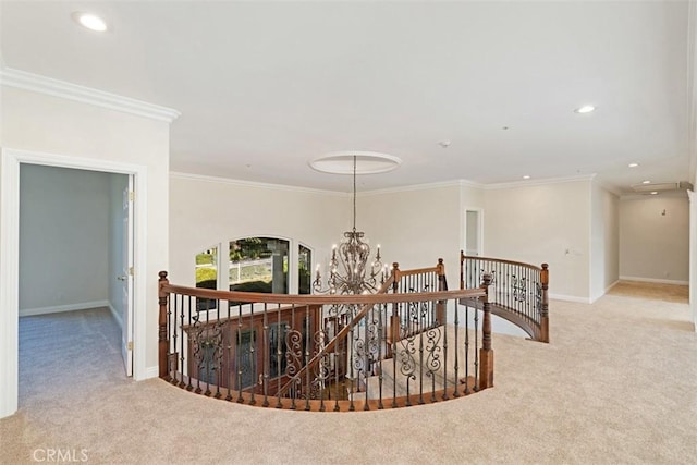 hallway with a notable chandelier, ornamental molding, and light carpet