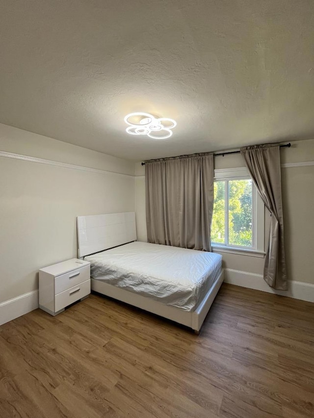 unfurnished bedroom with hardwood / wood-style floors and a textured ceiling