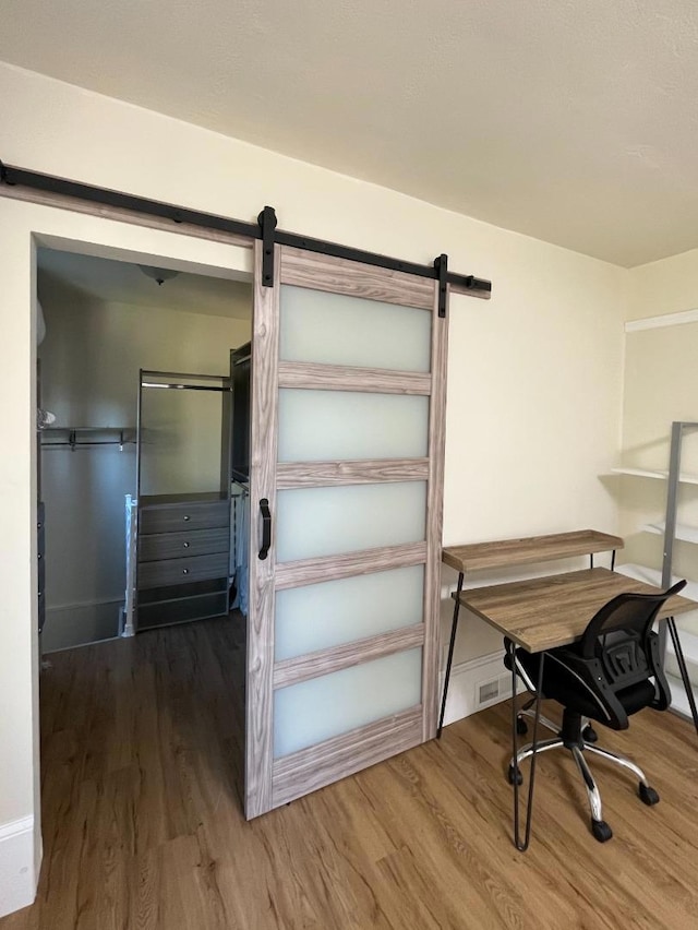 interior space with a barn door and hardwood / wood-style flooring