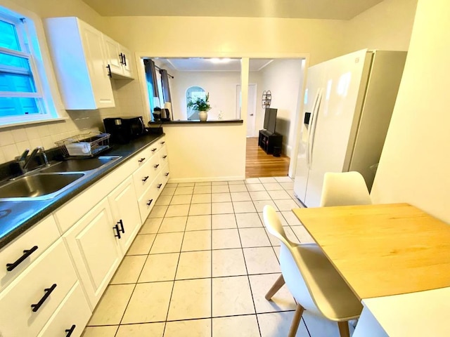 kitchen with backsplash, sink, white fridge with ice dispenser, and white cabinets