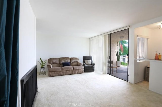 carpeted living room with radiator and an inviting chandelier