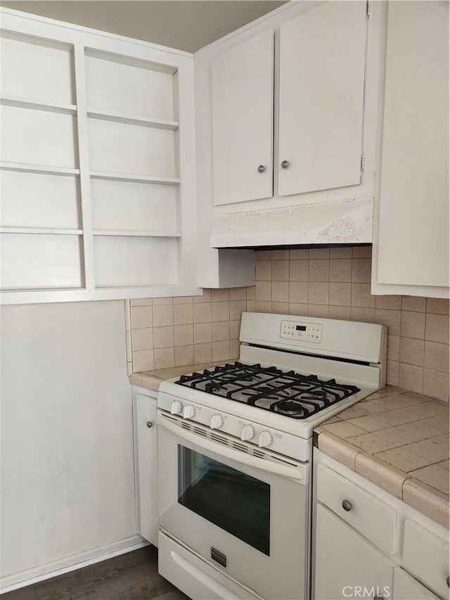 kitchen featuring decorative backsplash, dark hardwood / wood-style flooring, white cabinets, tile countertops, and white range with gas stovetop