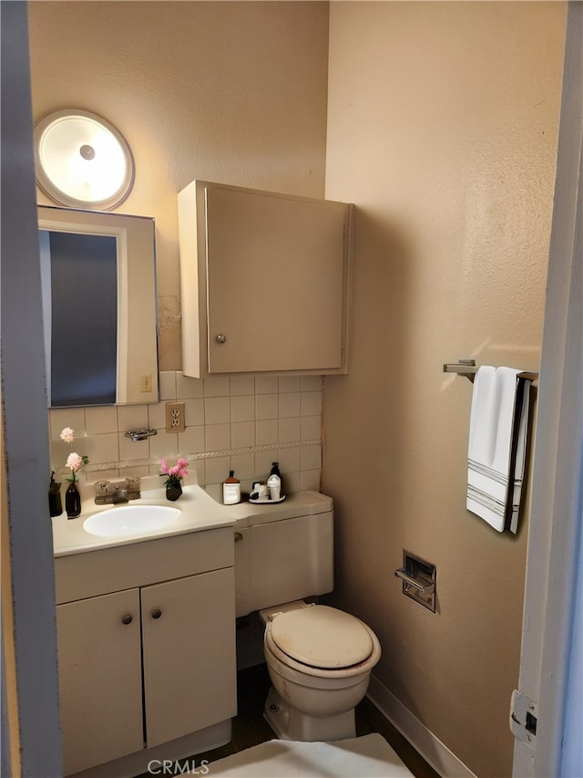 bathroom with vanity, decorative backsplash, and toilet