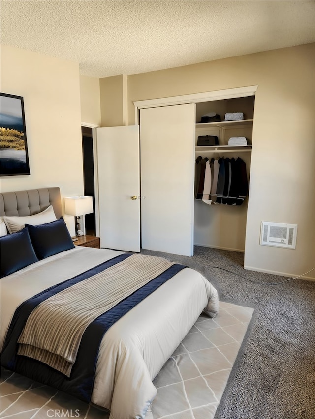 carpeted bedroom with a textured ceiling and a closet