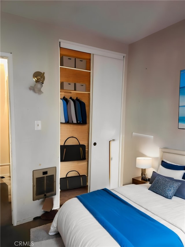 bedroom featuring heating unit and a closet