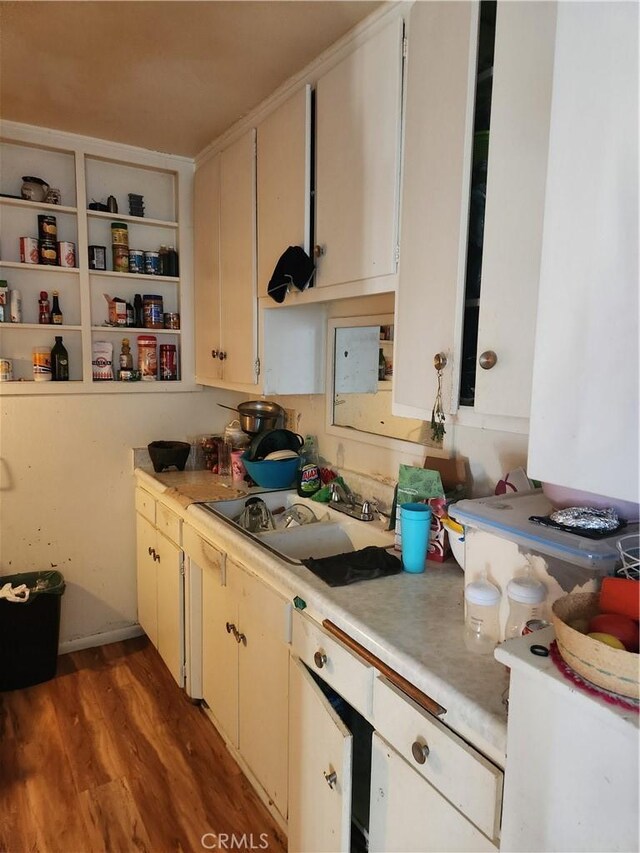 kitchen featuring hardwood / wood-style floors, sink, and white cabinets