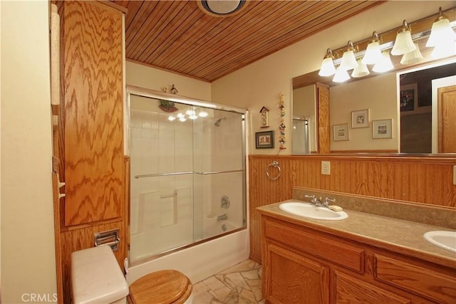 full bathroom featuring toilet, wood walls, bath / shower combo with glass door, wooden ceiling, and vanity