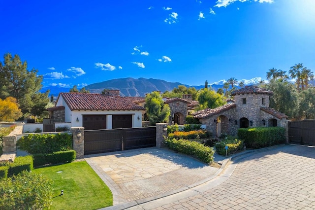 mediterranean / spanish house featuring a garage, a mountain view, and a front yard