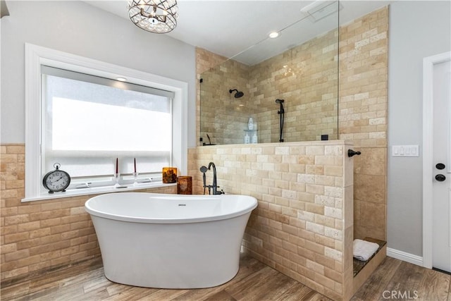 bathroom with shower with separate bathtub, hardwood / wood-style flooring, and tile walls