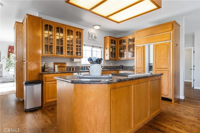 kitchen featuring a kitchen island, dark hardwood / wood-style flooring, and dark stone countertops