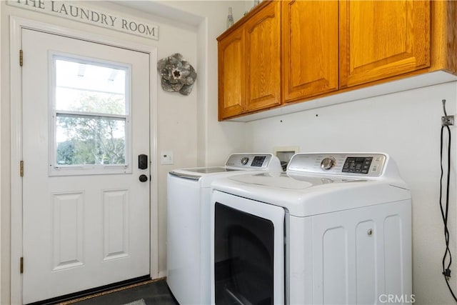 clothes washing area featuring cabinets and washing machine and dryer