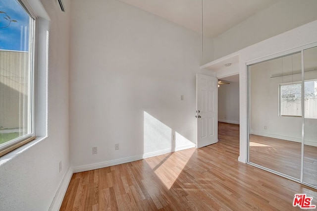 empty room with ceiling fan and light hardwood / wood-style floors