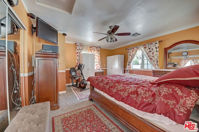 bedroom featuring a textured ceiling, carpet floors, ceiling fan, and ornamental molding