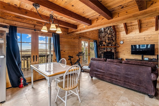 dining room featuring a notable chandelier, wooden ceiling, wooden walls, and french doors