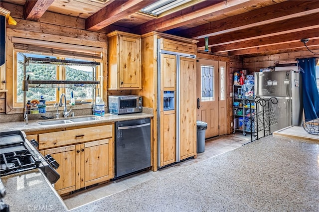 kitchen with beamed ceiling, appliances with stainless steel finishes, and sink