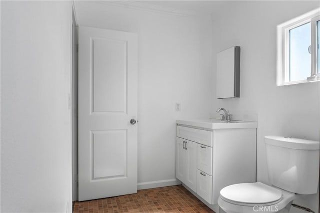 bathroom featuring toilet, crown molding, and vanity