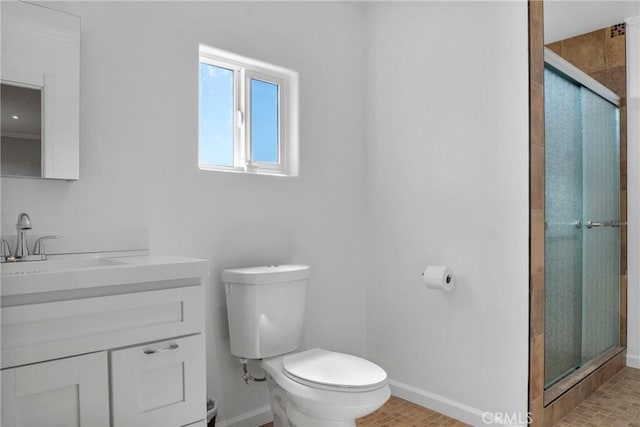 bathroom with toilet, vanity, a shower with door, and ornamental molding