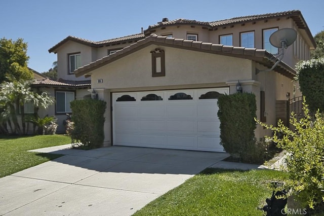 mediterranean / spanish house featuring a garage and a front lawn