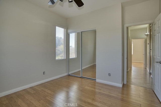 unfurnished bedroom featuring a closet, light hardwood / wood-style flooring, and ceiling fan