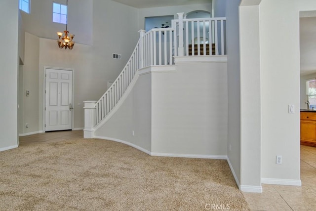 stairs with carpet, a high ceiling, and a chandelier