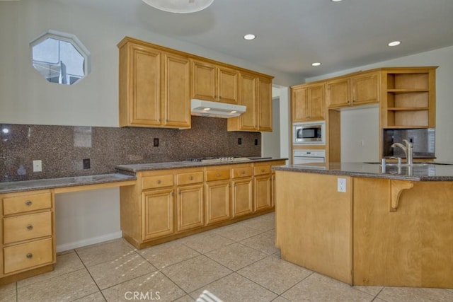 kitchen featuring tasteful backsplash, dark stone countertops, light tile patterned floors, and white appliances