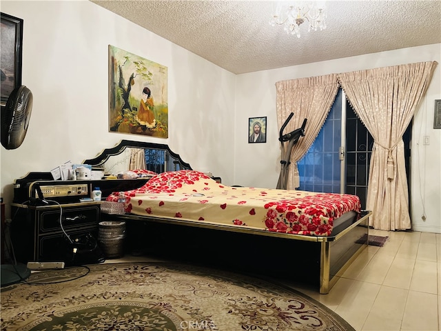 bedroom with a chandelier, light tile patterned flooring, and a textured ceiling