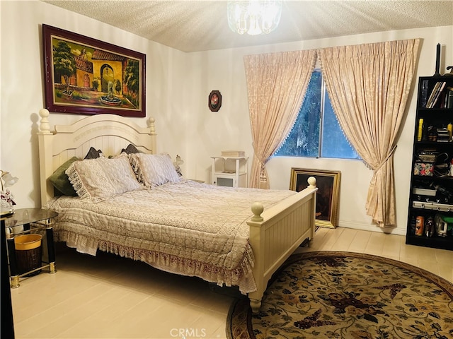 bedroom featuring a textured ceiling and a notable chandelier