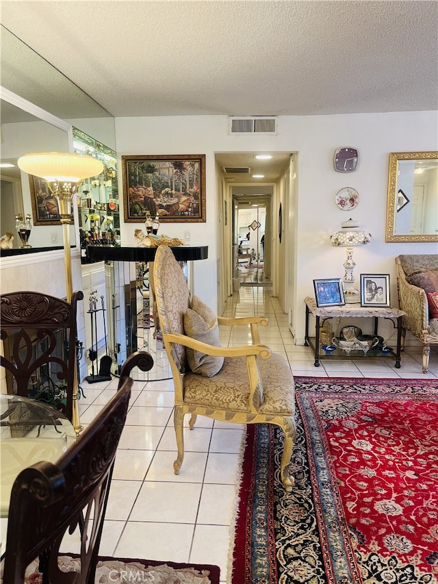 interior space featuring a textured ceiling, tile patterned floors, and a fireplace