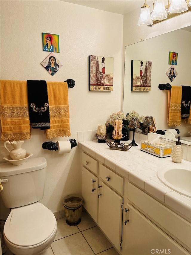 bathroom featuring toilet, vanity, and tile patterned flooring