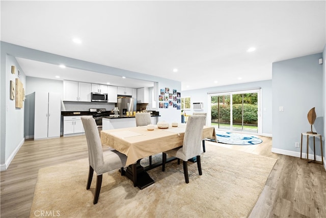 dining area with light wood-type flooring and a wall mounted AC