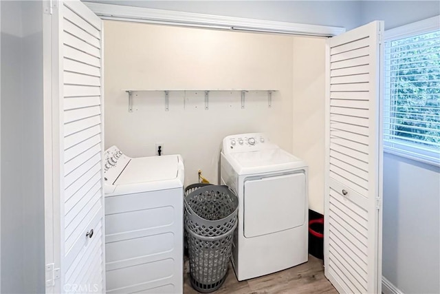 laundry area with washer and clothes dryer and light hardwood / wood-style flooring