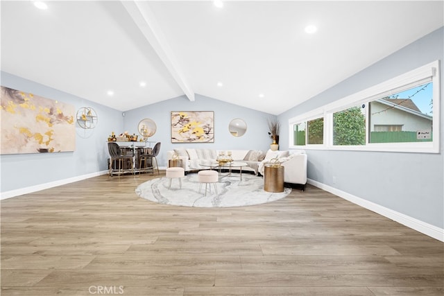 unfurnished living room featuring vaulted ceiling with beams and light hardwood / wood-style floors