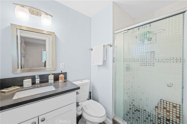 bathroom with walk in shower, vanity, and toilet