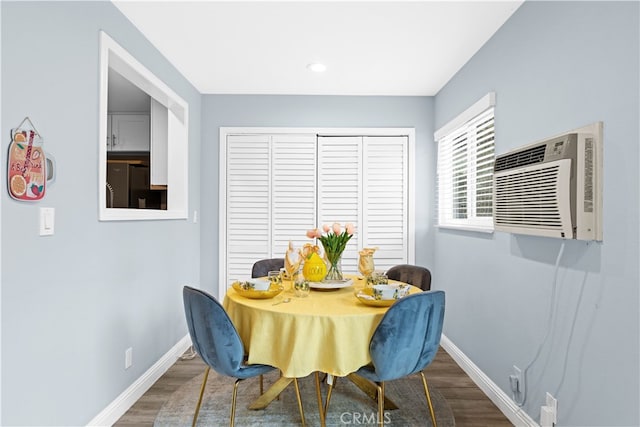 dining room with wood-type flooring and a wall unit AC