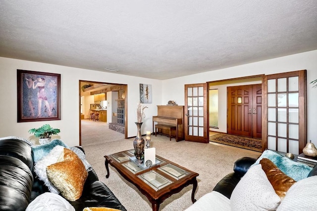 carpeted living room featuring french doors and a textured ceiling