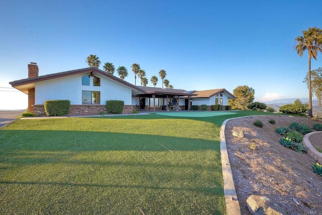 ranch-style house featuring a carport and a front lawn