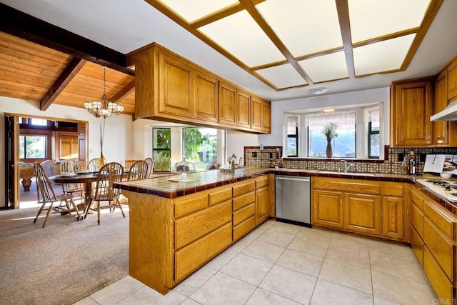 kitchen featuring appliances with stainless steel finishes, vaulted ceiling with beams, backsplash, kitchen peninsula, and light carpet