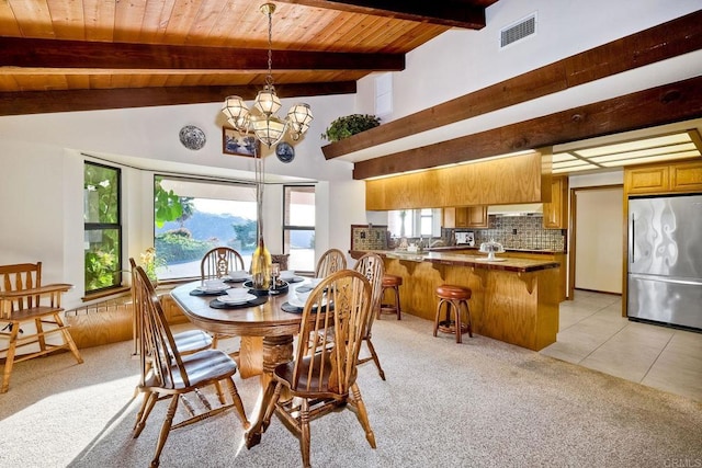 dining space featuring lofted ceiling with beams, light carpet, and wood ceiling