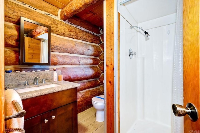 bathroom with vanity, toilet, curtained shower, and rustic walls