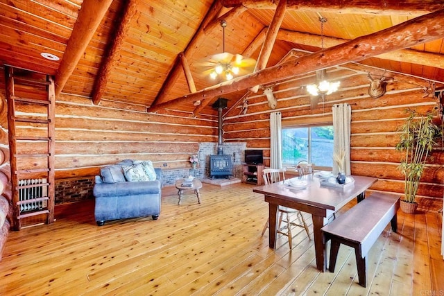 dining area with wood ceiling, hardwood / wood-style flooring, a wood stove, and rustic walls