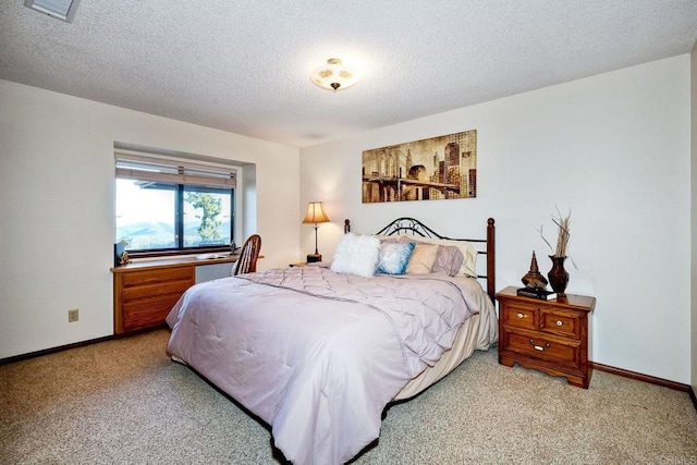 bedroom with light carpet and a textured ceiling