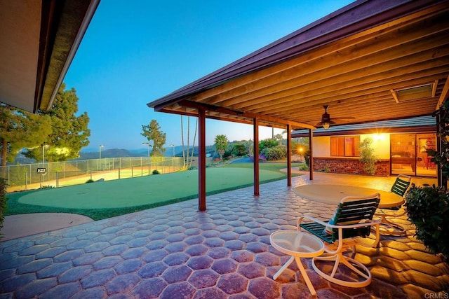 patio terrace at dusk featuring ceiling fan