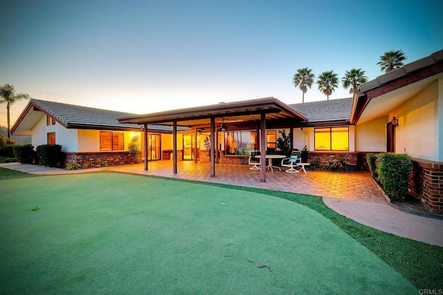 back house at dusk with a patio