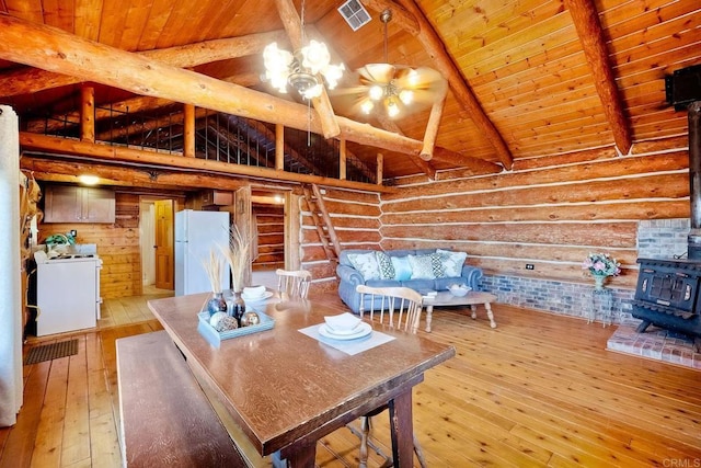 interior space featuring a wood stove, beam ceiling, and light wood-type flooring