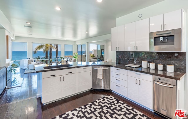 kitchen with kitchen peninsula, a water view, and dark hardwood / wood-style flooring